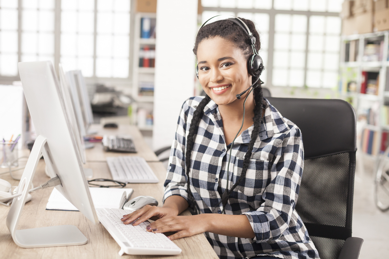 A woman working as a contact center agent and using a desktop computer with access to Amazon Connect and Amazon Connect Tasks