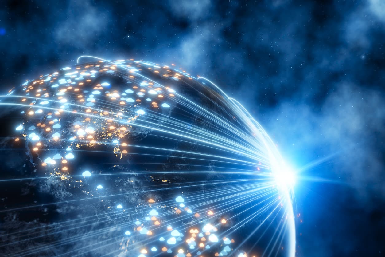 This abstract image shows a globe on a black background with blue clouds around it. There’s a glowing light with lines coming off of it, connecting various points of light on the globe.