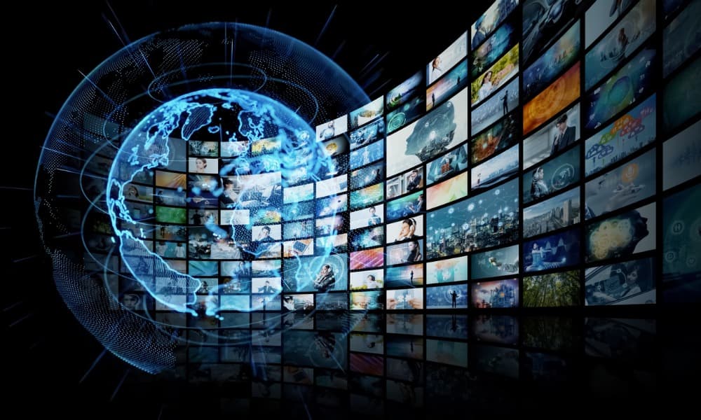 A large blue globe emits a long line of video screens.
