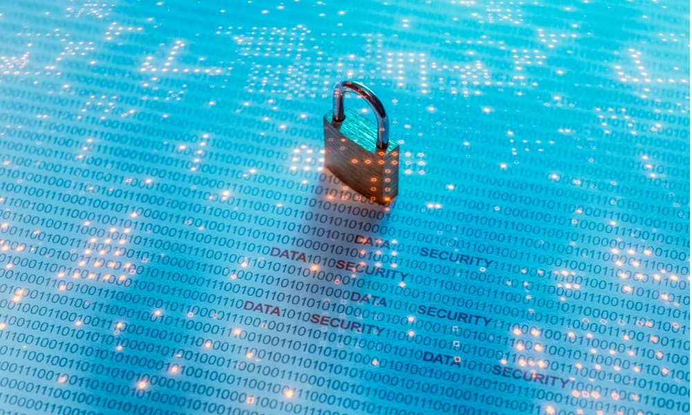 Light blue background with lights simulating a computer chip, an old-fashioned padlock sits on top of the lighted chip display.