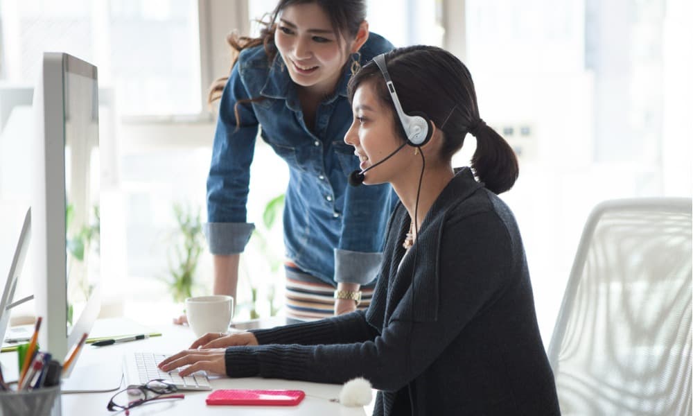 An employee shows a colleague how to turn your Amazon Connect call center into a fully featured contact center.