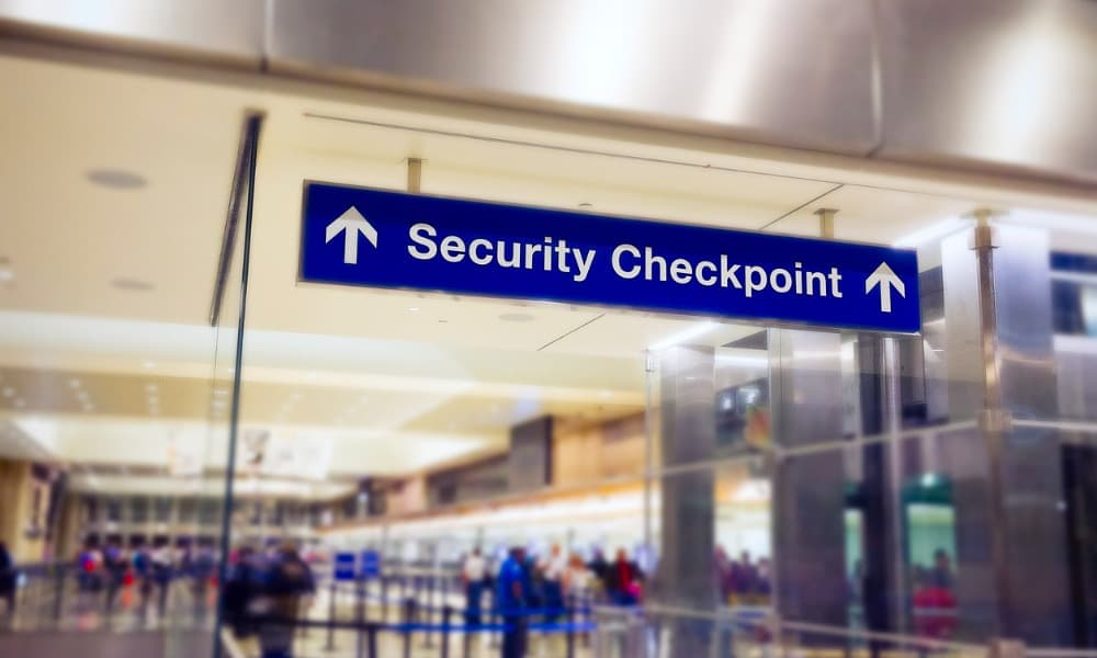 The image displays signage indicating a security checkpoint ahead.