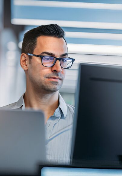 guy with glasses in front of a computer